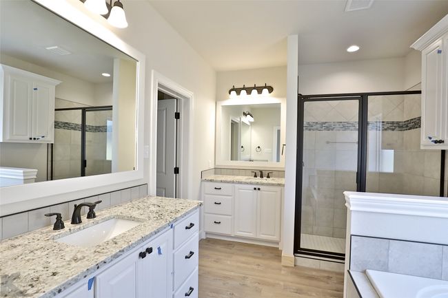 Full bathroom featuring a shower stall, wood finished floors, two vanities, recessed lighting, and a bathtub | Image 4