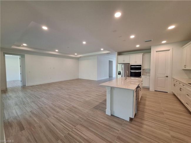 Great room with tray ceiling and open-concept kitchen | Image 4
