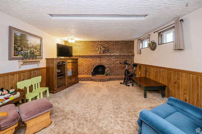 Living area with wooden walls, wainscoting, and a textured ceiling | Image 35