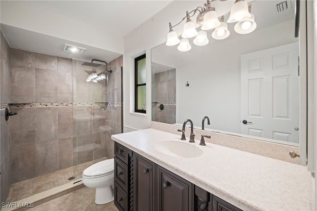 Full bath featuring vanity, tiled shower, and tile patterned flooring | Image 15