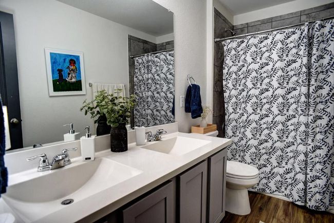 Full bath featuring toilet, wood finished floors, a sink, and double vanity | Image 31
