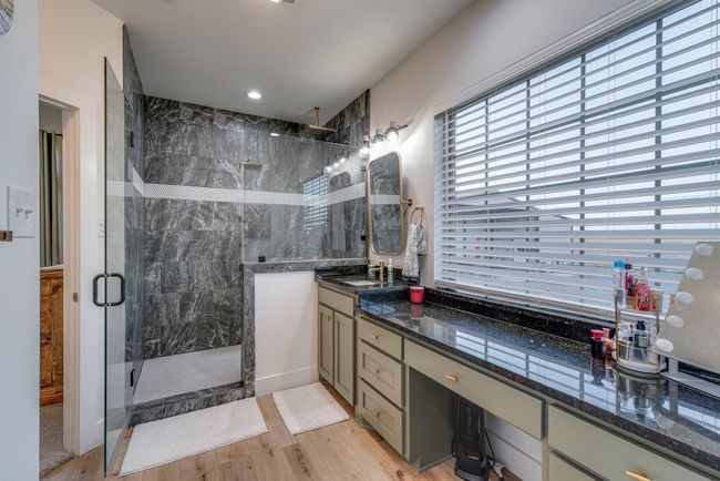 Bathroom with oversized walk in shower, rain shower head, body sprayers, LVP flooring, and large vanity. | Image 14