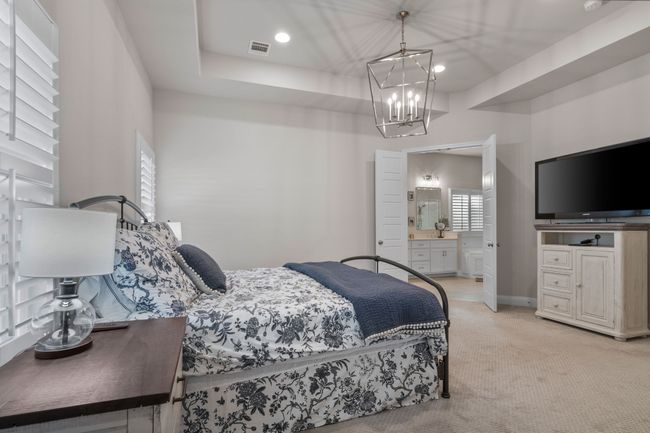 Bedroom with visible vents, recessed lighting, light carpet, a notable chandelier, and connected bathroom | Image 14