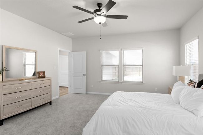 Bedroom with light colored carpet, visible vents, baseboards, and a ceiling fan | Image 22