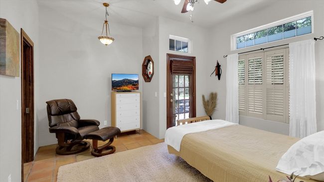 East Bedroom number 4 featuring a high ceiling and light. There is a private entrance fron the front driveway to this area. | Image 38