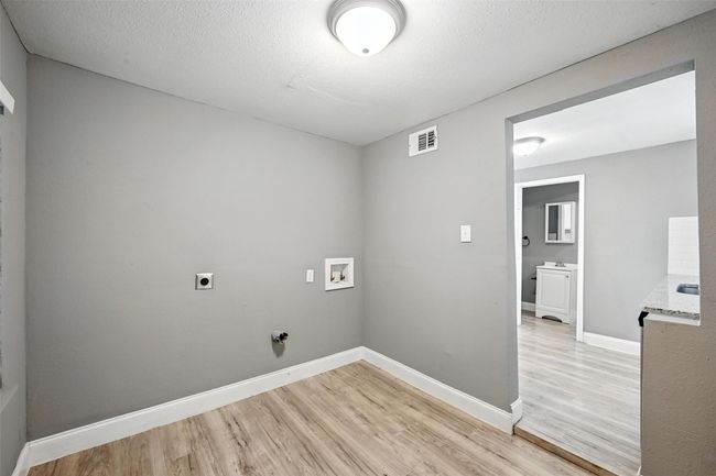 Washroom featuring light wood finished floors, hookup for a washing machine, and hookup for an electric dryer | Image 15