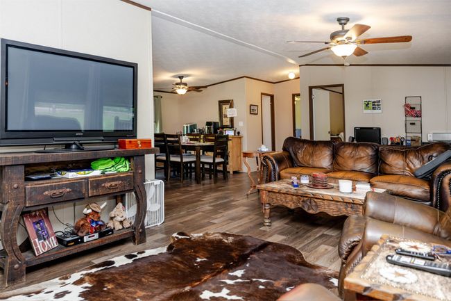 Living area with wood finished floors, ornamental molding, and a ceiling fan | Image 16