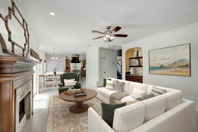 The family room has a gas log fireplace, a dry bar, and is open to the breakfast area and kitchen beyond. Photo is virtually furnished. | Image 5