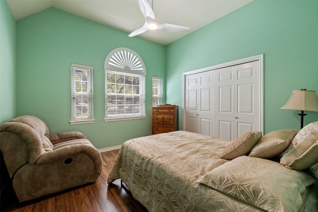 Bedroom with wood finished floors, a closet, vaulted ceiling, baseboards, and a ceiling fan | Image 30