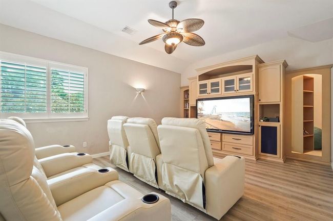 Cozy home theater room with comfortable recliners that are staying with the house, a large built-in entertainment center. Enter the "secret room" through the bookshelf | Image 12
