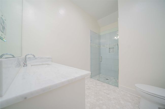 Bathroom with vanity, a shower stall, vaulted ceiling, and tile patterned flooring | Image 25