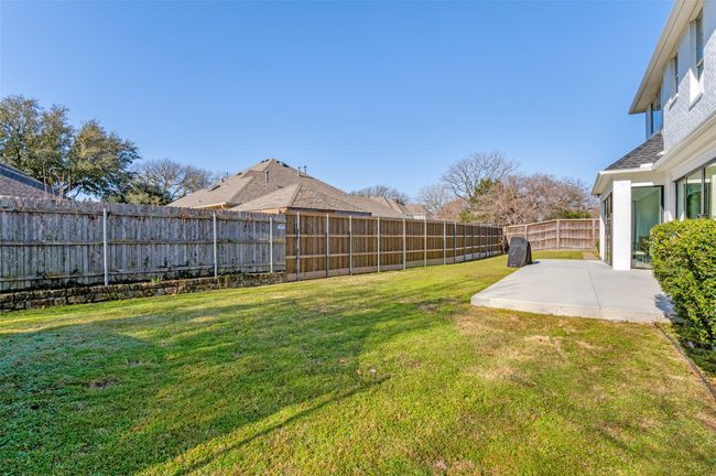 View of yard featuring a fenced backyard and a patio area | Image 35
