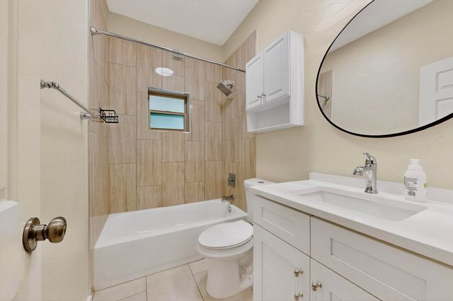 Bathroom with vanity, tile patterned floors, and shower / tub combination | Image 25