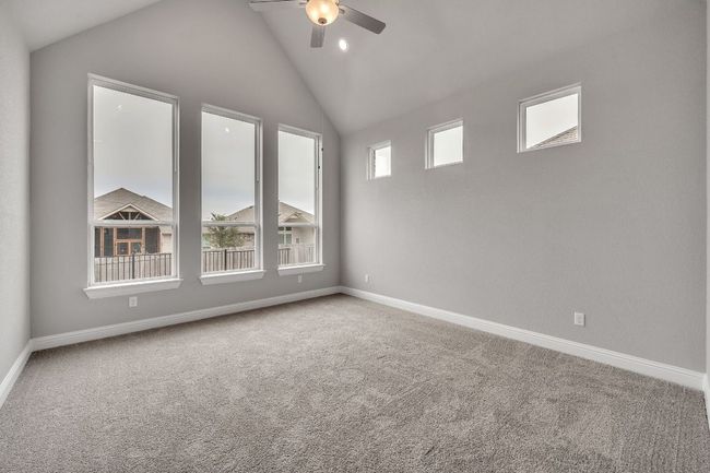 Carpeted spare room featuring ceiling fan, a wealth of natural light, and baseboards | Image 15