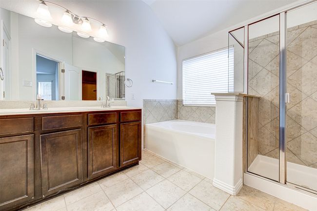 Full bathroom with lofted ceiling, tile patterned floors, a bath, a shower stall, and double vanity | Image 18