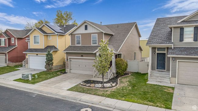 View of front of house with a front lawn, driveway, board and batten siding, fence, and a garage | Image 27