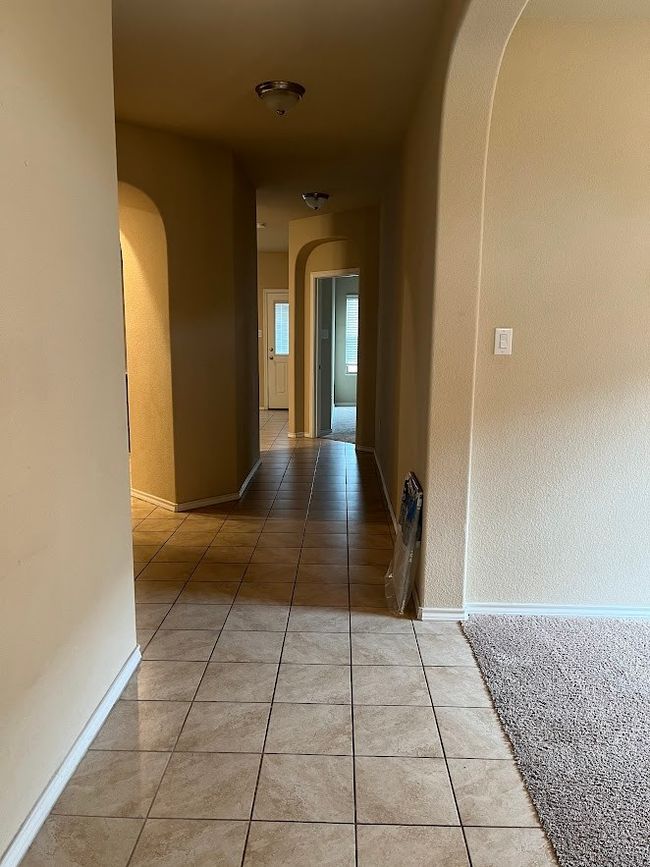 Hallway featuring arched walkways, light tile patterned flooring, and baseboards | Image 21