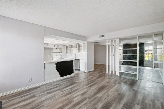 Unfurnished living room with wood finished floors and a textured ceiling | Image 6