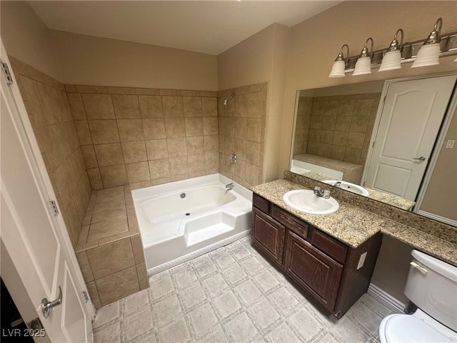Full bath with tile patterned floors, toilet, bathtub / shower combination, and vanity | Image 20