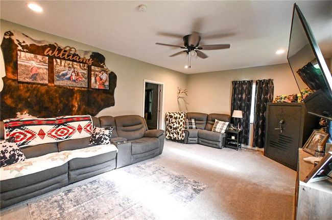 Carpeted living room featuring a ceiling fan and recessed lighting | Image 18