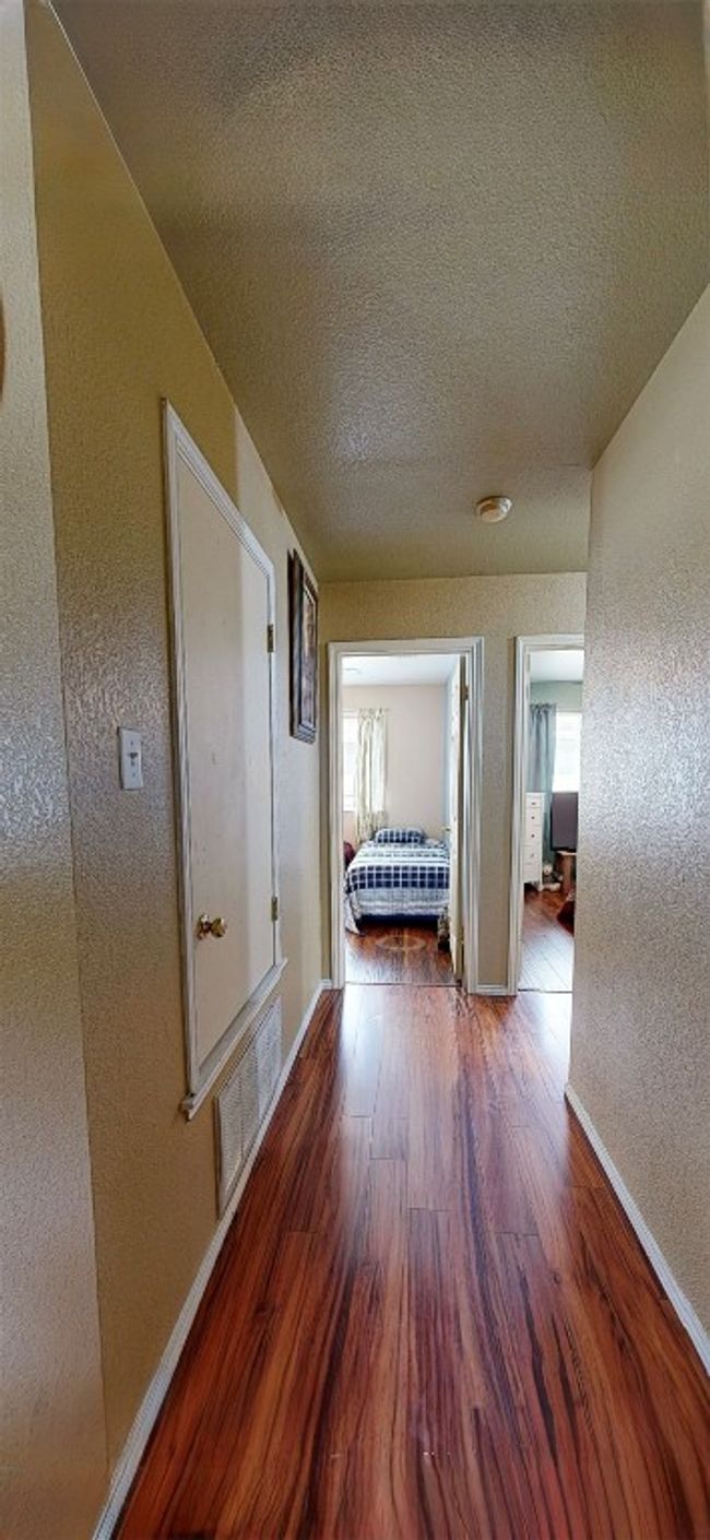 Hallway featuring wood finished floors, a textured wall, and a textured ceiling | Image 19