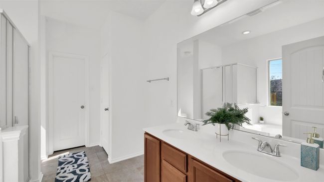 Full bathroom with double vanity, a stall shower, tile patterned flooring, and a sink | Image 23