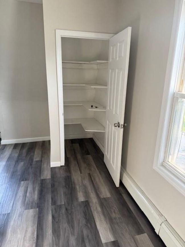 Closet featuring a baseboard heating unit | Image 7