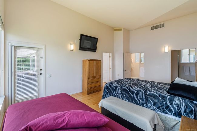 Bedroom with wood finished floors, high vaulted ceiling, baseboards, and connected bathroom | Image 28