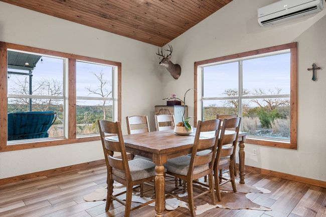 Dining space featuring lofted ceiling, wooden ceiling, light wood-type flooring, and an AC wall unit | Image 15