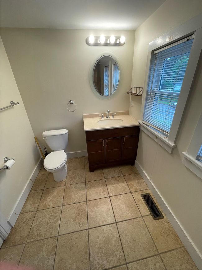 Bathroom with toilet, vanity, tile patterned floors, and baseboards | Image 9