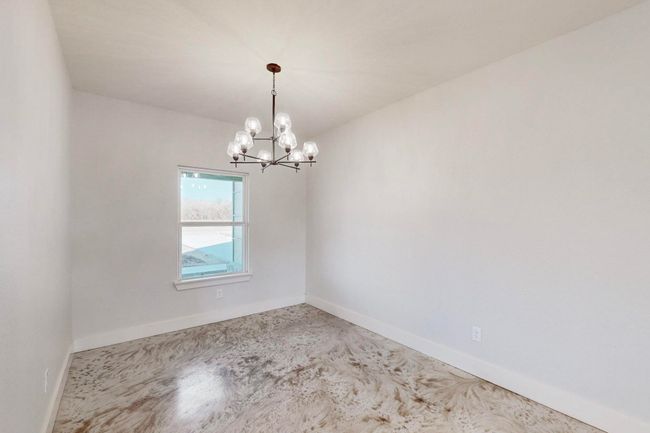 Spare room featuring a notable chandelier and baseboards | Image 19