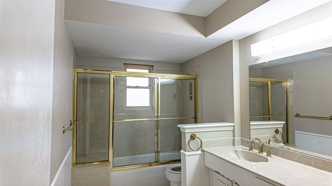Bathroom featuring shower / bath combination with glass door, vanity, and toilet | Image 28