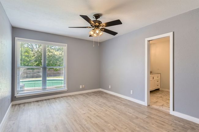 Empty room with light wood finished floors and a ceiling fan | Image 15