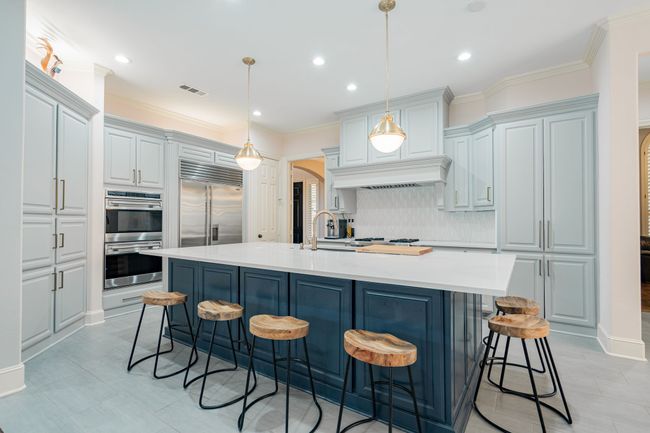 Kitchen featuring a breakfast bar area, arched walkways, stainless steel appliances, backsplash, and visible vents | Image 10