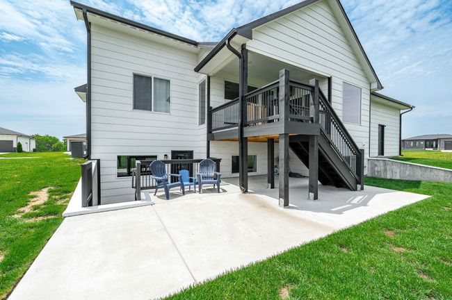 Rear view of house featuring a patio area, a lawn, central AC unit, a wooden deck, and stairway | Image 34