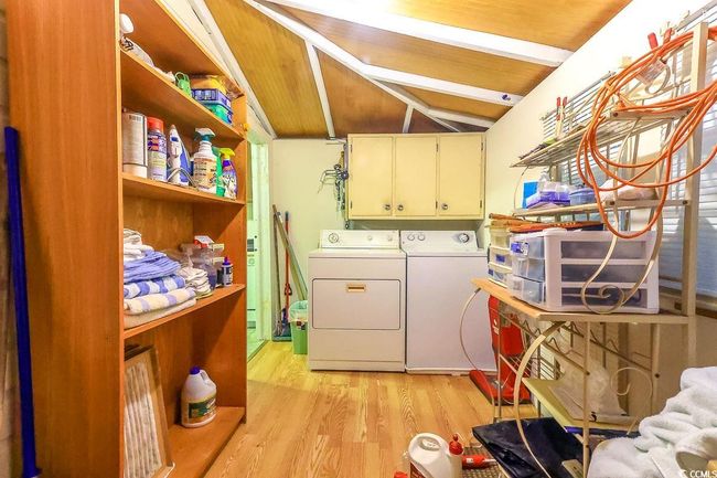 Washroom featuring washer and clothes dryer, cabinet space, and light wood finished floors | Image 13