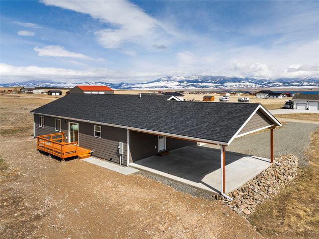 Back of property featuring driveway, a shingled roof, a carport, and a mountain view | Image 15