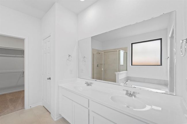 The en-suite bathroom offers a spa-like atmosphere with its elegant design, high end finishes, and tasteful lighting, creating a retreat within your own home. | Image 12