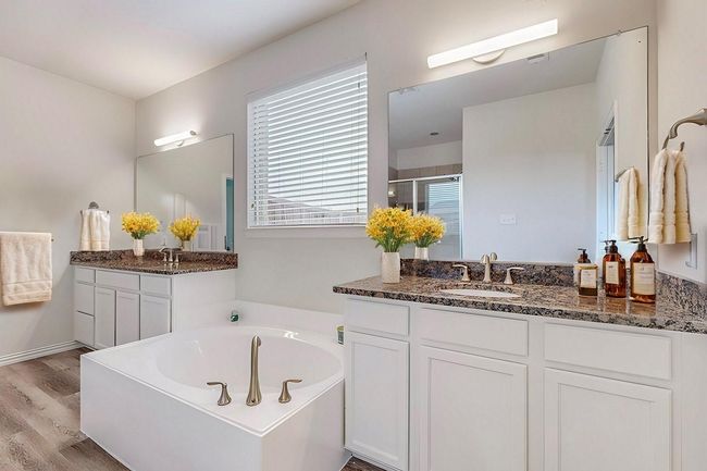 Full bathroom with a shower stall, a bath, wood finished floors, and two vanities | Image 9