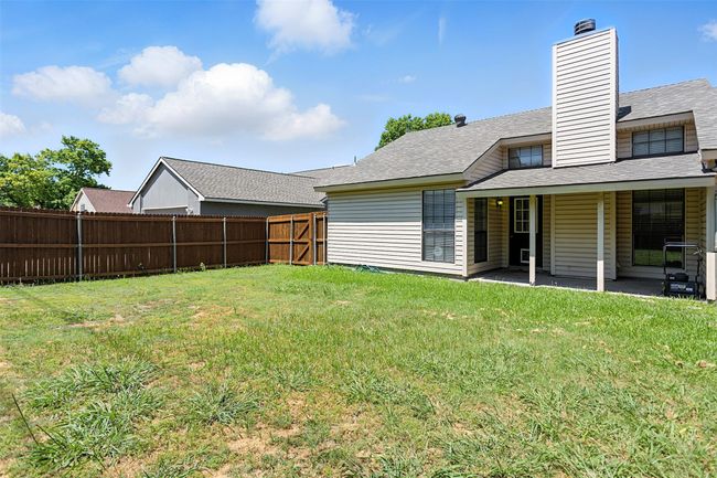 Fenced backyard with a patio area | Image 24