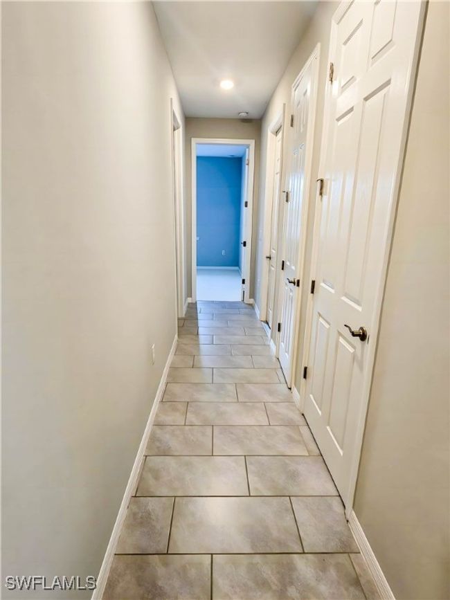 Hall with baseboards and light tile patterned floors | Image 11