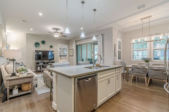 Kitchen with dishwasher, a sink, open floor plan, a kitchen island with sink, and light wood finished floors | Image 15