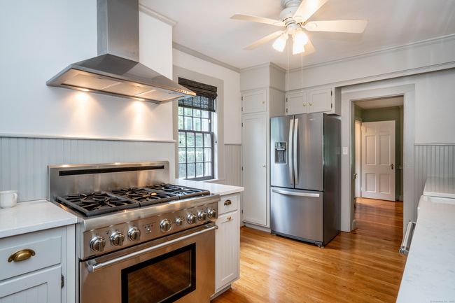 Thermador oven range with gas burners. Armoire style refrigerator with freezer on the bottom. | Image 9