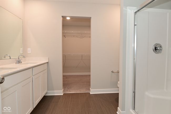 full bath with a walk in closet, baseboards, a shower stall, and vanity | Image 44