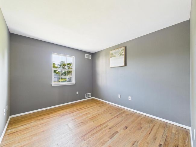Spare room featuring wood finished floors and baseboards | Image 25