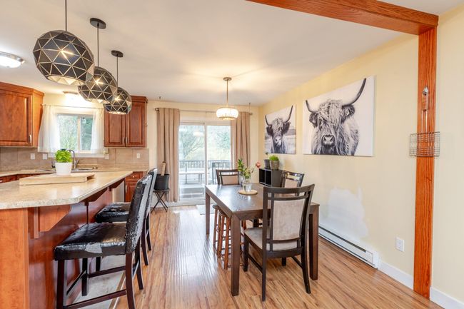 Dining space featuring a baseboard radiator, plenty of natural light, and light wood-type flooring | Image 11