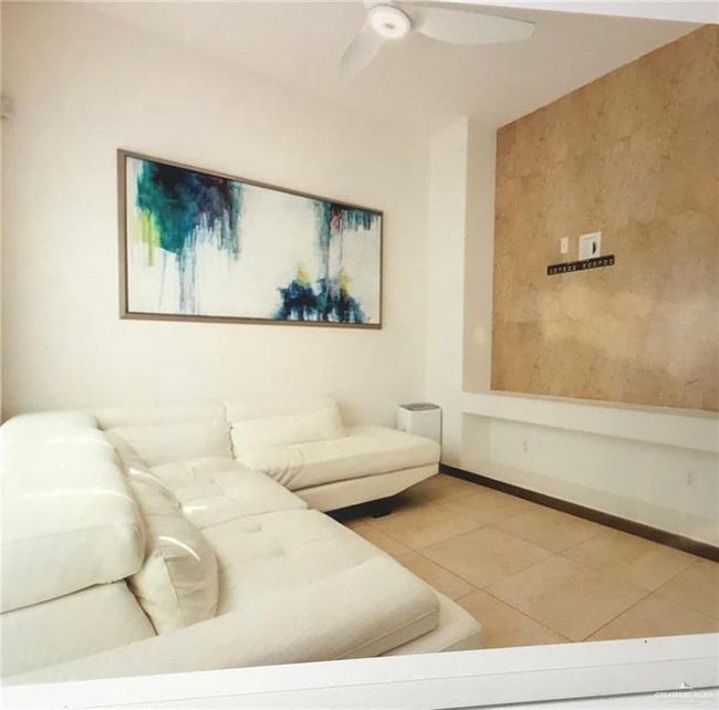 Living area featuring tile patterned floors, a ceiling fan, and baseboards | Image 5