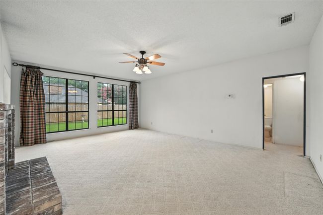 Unfurnished living room featuring a ceiling fan, carpet flooring, and a textured ceiling | Image 10