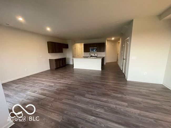 unfurnished living room with baseboards, dark wood-style floors, and recessed lighting | Image 7