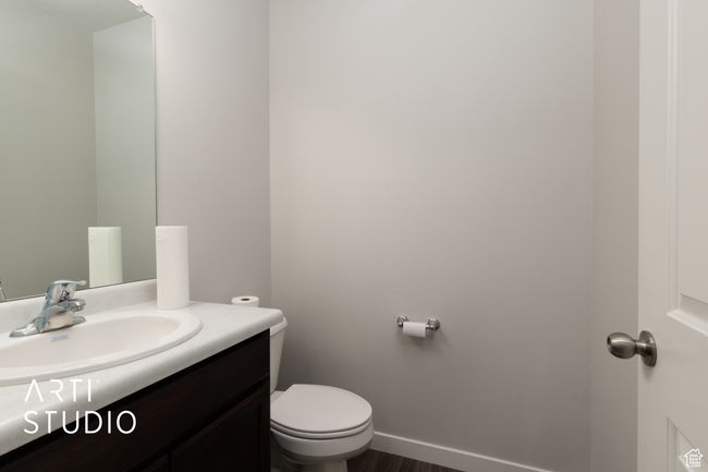 Bathroom featuring vanity, toilet, wood finished floors, and baseboards | Image 6